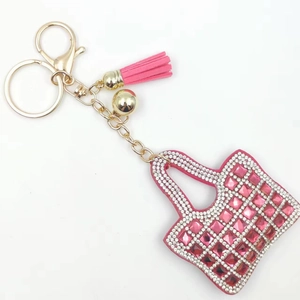 Detailed close-up of pink rhinestone handbag keychain with golden tassel and lobster clasp