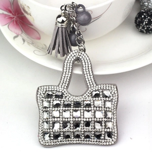 Detailed view of mini handbag keychain with sparkling rhinestones and grey leather tassel