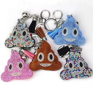 Detail of colorful rhinestone emoji poop keychains with matching leather tassels