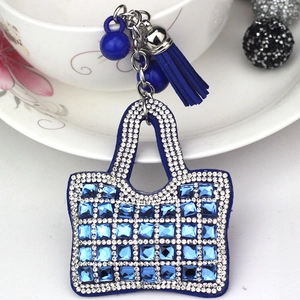 Detail shot of mini blue handbag keychain with crystal rhinestones and blue tassel charm