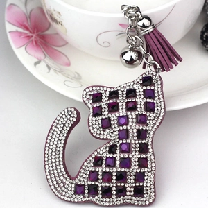 Détail d'un porte-clés chat en cristal avec gemmes violettes et pompon en daim doux