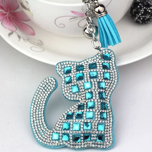 Porte-clés chat bleu avec strass, clochette argentée et pompon sur tasse blanche