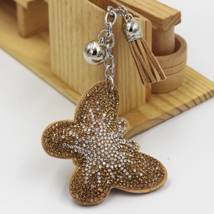 Porte-clés papillon brillant avec strass marrons, clochette et pompon en cuir élégant