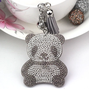 Detail of cute panda keychain with silver rhinestones, grey tassel and small bell