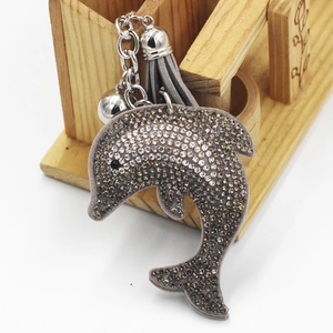 Détail d'un porte-clés dauphin gris orné de strass brillants et d'un long gland gris