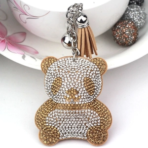 Detailed view of rhinestone panda keychain with beige leather tassel and silver bell
