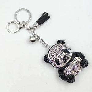 Detail of cute panda keychain with black and crystal rhinestones, silver bell and tassel