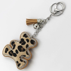 Dettaglio portachiavi orsetto leopardato con strass argentati e nappa in pelle marrone