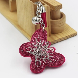 Porte-clés papillon strass rose avec clochette argentée et gland en daim élégant
