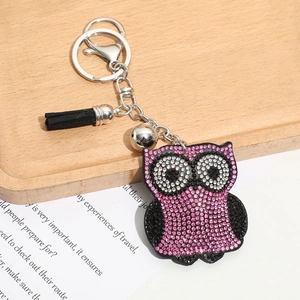Gros plan du porte-clés hibou en strass rose avec pompon noir et fermoir argenté
