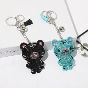 Détail de porte-clés tigre en strass avec cloches et glands en bleu et noir élégant