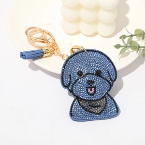 Vue détaillée du porte-clés caniche en strass bleus avec clochette et pompon bleu