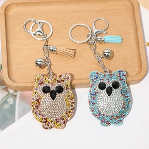 Détail de porte-clés hibou étincelants avec strass, clochette en métal et glands en cuir