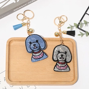Détail de porte-clés chien teddy étincelants avec strass, glands et petites cloches dorées