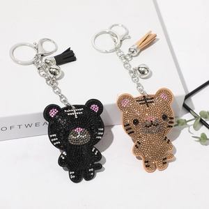 Détail de porte-clés tigre en strass avec glands assortis et petites cloches argentées