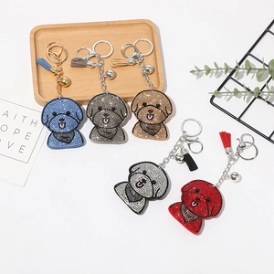 Détail de porte-clés chien en strass avec pompons déclinés en cinq couleurs