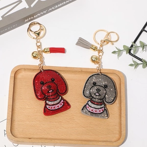 Détail de porte-clés chien teddy gris et rouge avec strass brillants et pompons