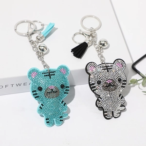 Détails des porte-clés tigre en cristal avec pompons bleus et argentés et clochettes
