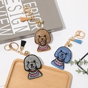 Détail de porte-clés chien en strass brillants avec pompons en trois couleurs variées
