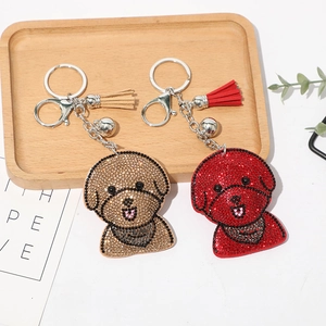 Détails de porte-clés chien en strass brillants avec pompons et cloches sur plateau bois