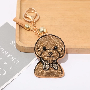 Porte-clés chien en strass brillant avec métal doré et pompon en cuir marron élégant