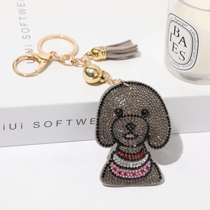 Porte-clés chien teddy en strass gris avec pompon et fermoir doré élégant sur coffret