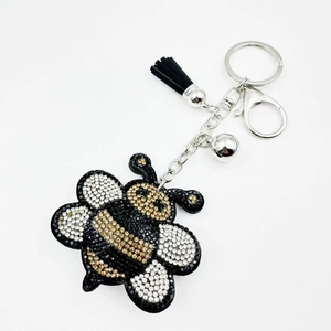 Close-up of cute bee keychain with sparkling rhinestones and black leather tassel detail