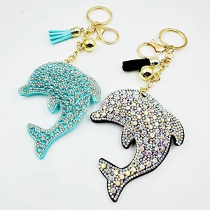 Detailed close-up of crystal-encrusted dolphin keychains with blue and black rhinestones