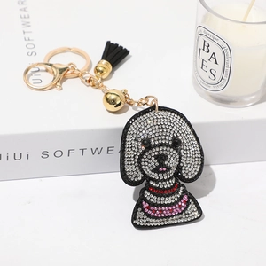Détail d'un porte-clés chien teddy avec strass, fermoir doré et gland en cuir noir