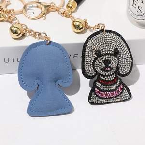 Détail macro du porte-clés chien en strass avec fermoir doré et dos en daim bleu élégant