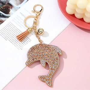 Detail of crystal dolphin keychain with orange rhinestones and light brown tassel