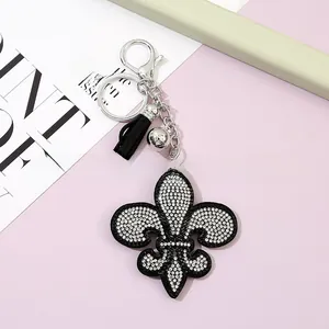 Porte-clés fleur de lys avec strass, pompon noir et clochette argentée élégante