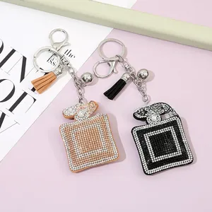 Detailed view of perfume bottle keychains with crystal rhinestones and leather tassels