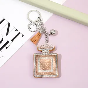 Detailed view of rhinestone perfume bottle keychain with tassel and silver metal ring