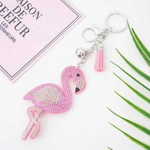 Rosa Flamingo Schlüsselanhänger mit Strass, Quaste und Glocke auf weißem Hintergrund