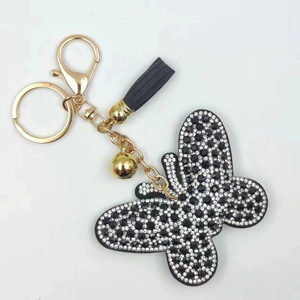 Butterfly rhinestone keychain with black tassel and gold bells on white background