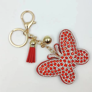 Close-up of butterfly rhinestone keychain with red tassels and gold metal hardware