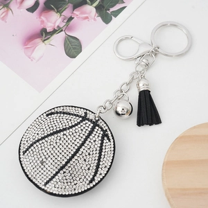 Dettaglio ravvicinato di un portachiavi da basket con strass scintillanti e nappa di seta nera