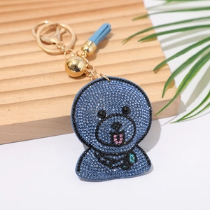 Blue rhinestone dog keychain with a light blue tassel and gold metal hook on tray
