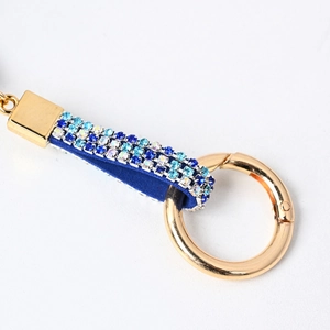 Dettaglio portachiavi a stella con strass blu scintillanti su cinturino in velluto morbido
