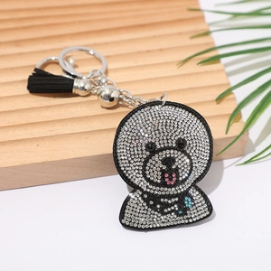 Detail shot of a sparkling rhinestone cartoon dog keychain with a black PU tassel