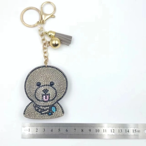 Detailed view of rhinestone bear keychain with grey tassel and gold lobster clasp