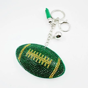 Dettaglio portachiavi da rugby con strass verdi e gialli e nappa in pelle abbinata