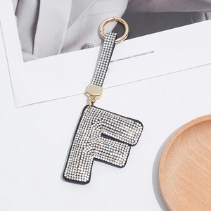 Detail of letter F keychain featuring sparkling rhinestones and a gold metal ring