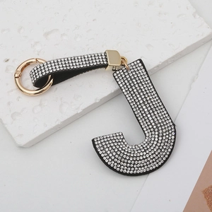 Détail du porte-clés lettre J avec strass étincelants et fermoir en métal doré brillant