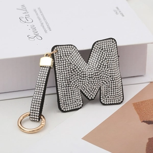 Vue détaillée du porte-clés lettre M de luxe avec strass brillants et métal doré