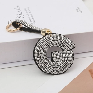 Vue détaillée du porte-clés lettre G incrusté de strass avec des finitions dorées élégantes