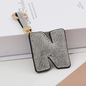Détail du porte-clés lettre N serti de strass avec anneau doré et lanière en cuir