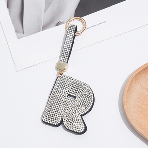 Detail of letter R keychain with white rhinestones and a gold-tone climbing hook