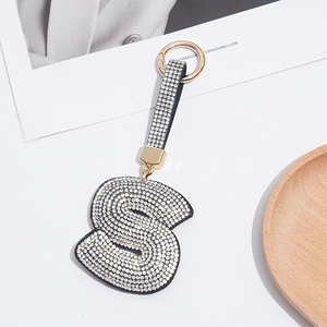 Detailed view of luxury letter S keychain with rhinestones and golden metal ring